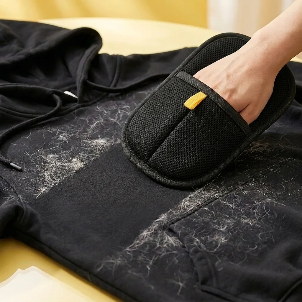 FurSweep Mitt collecting pet hair from black clothing.